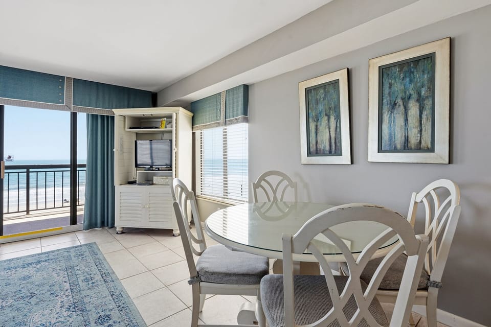 Dining table beside doors to the ocean view balcony at Buena Vista Plaza 501, a 3-bedroom Cherry Grove condo