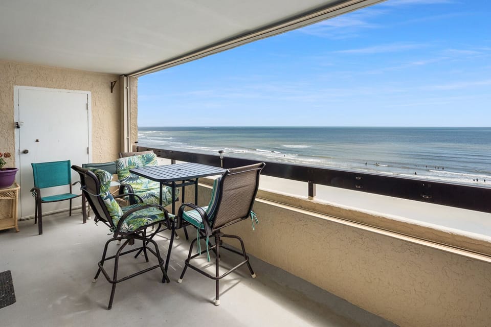Oceanfront balcony with a table and four chairs at Sea Pointe 707, a 3-bedroom Cherry Grove condo