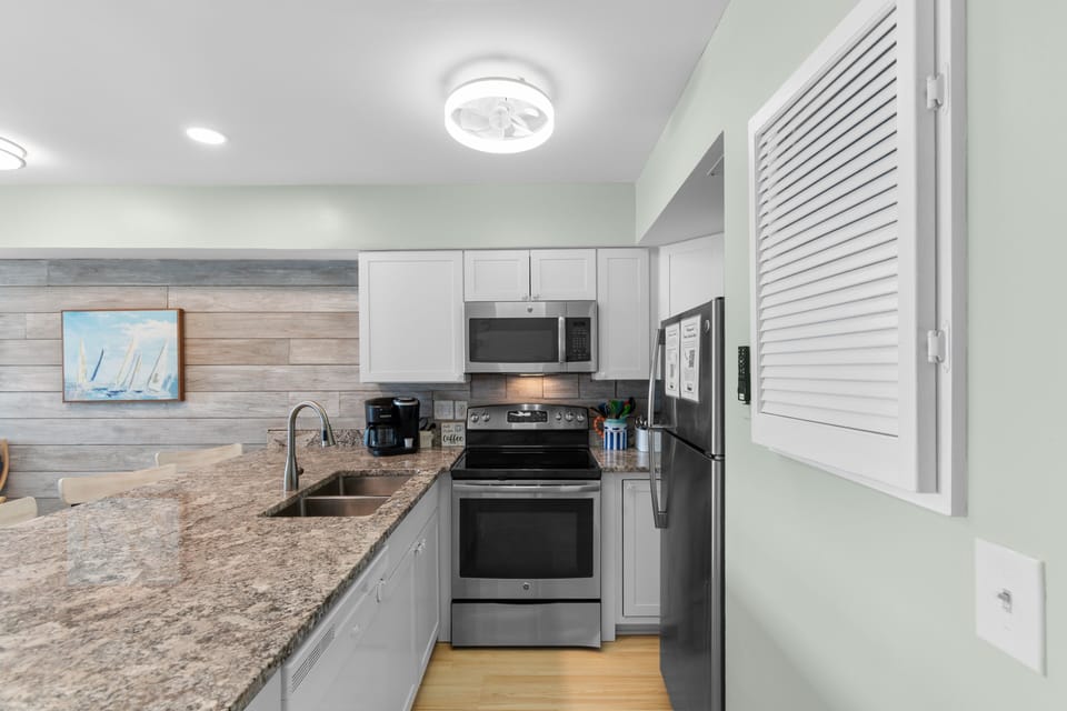 Your modern kitchen features stainless appliances, a coffee maker for easy mornings, and calming coastal décor that sets a relaxing beach-getaway tone.