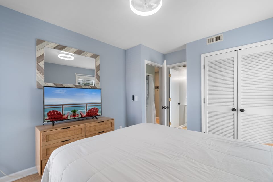 Unwind in your coastal retreat with soothing blue tones, a plush bed, and beachside scenes to inspire your mornings.
