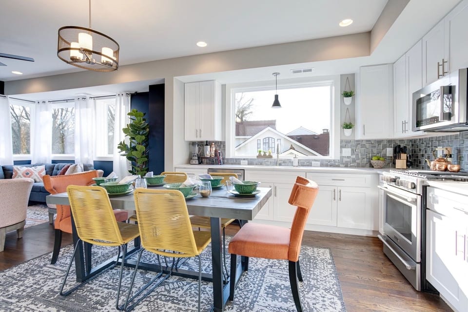 - Bright, modern kitchen with oversized window, stainless appliances & cheerful vibes - Gather around a bold dining table with eclectic chairs & playful textures - Perfect flow into the cozy living space, ideal for sharing meals & memories