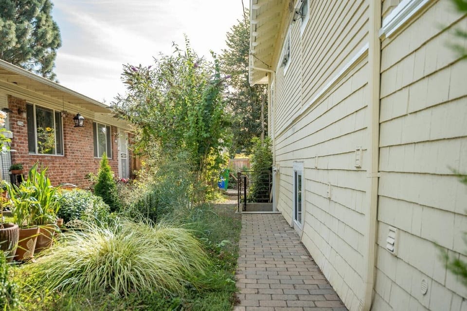 Stairs leading down to apartment door. Pathway is well lit at night.