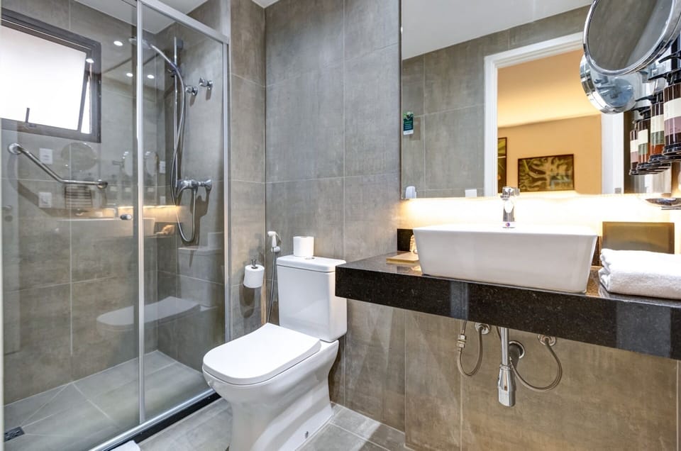 Deluxe Room, 1 King Bed | Bathroom | Rainfall showerhead, free toiletries, hair dryer, towels