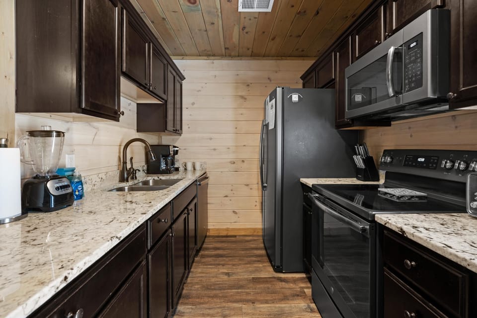 The kitchen is fully stocked with dishes, pots, pans, and stainless steel appliances. Both a drip coffee maker and Keurig are at your service!