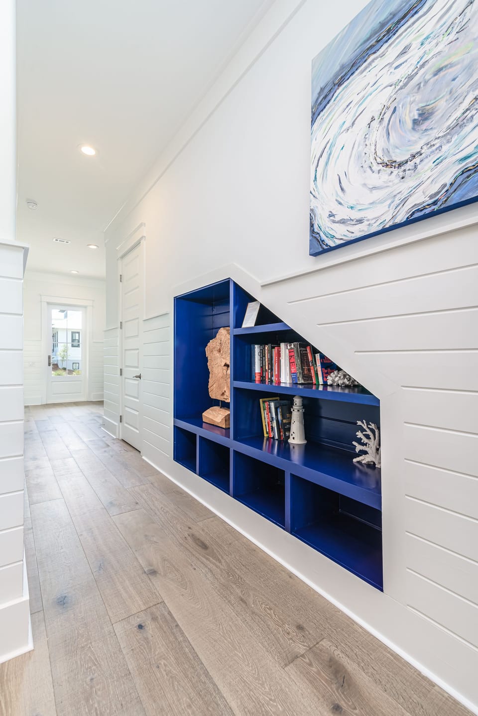 Downstairs Hallway features a built in display shelf with art and a library!