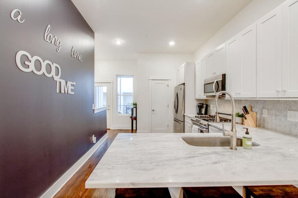 Kitchen island close-up with marble countertop and bar stools — managed by Host Extraordinaires