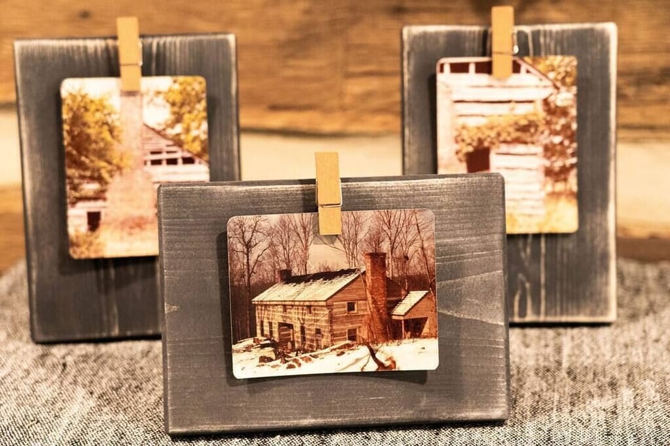 Pictures of the original cabin in the backround and cabin in its current location today before renovations in the foreground.