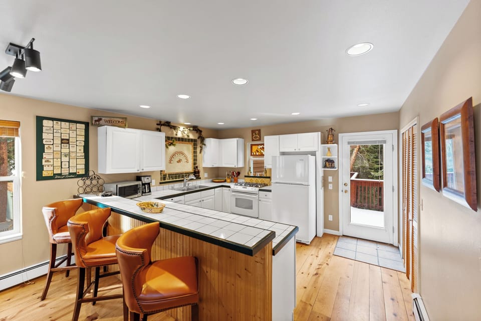 Cook memorable meals in your spacious kitchen featuring warm wood floors, granite counters, and a welcoming breakfast bar perfect for morning coffee.
