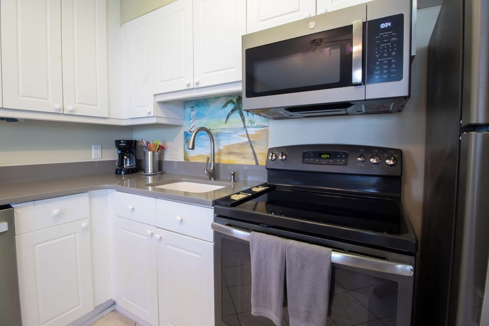 Your fully equipped kitchen awaits with modern stainless-steel appliances, crisp white cabinetry, and everything you need to prepare fresh meals during your coastal getaway.