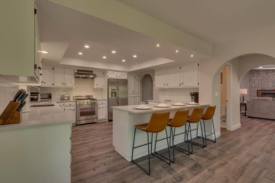 - Fully equipped kitchen with modern appliances  
- Spacious island with bar seating for four  
- Stainless steel fridge and gas range cooking
