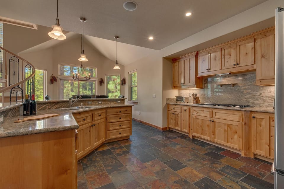 - Spacious kitchen with granite counters  
- Modern appliances and wood cabinets  
- Open layout with forest views