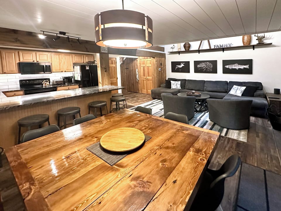 Cool schoolhouse pendant hovers over massive custom table.