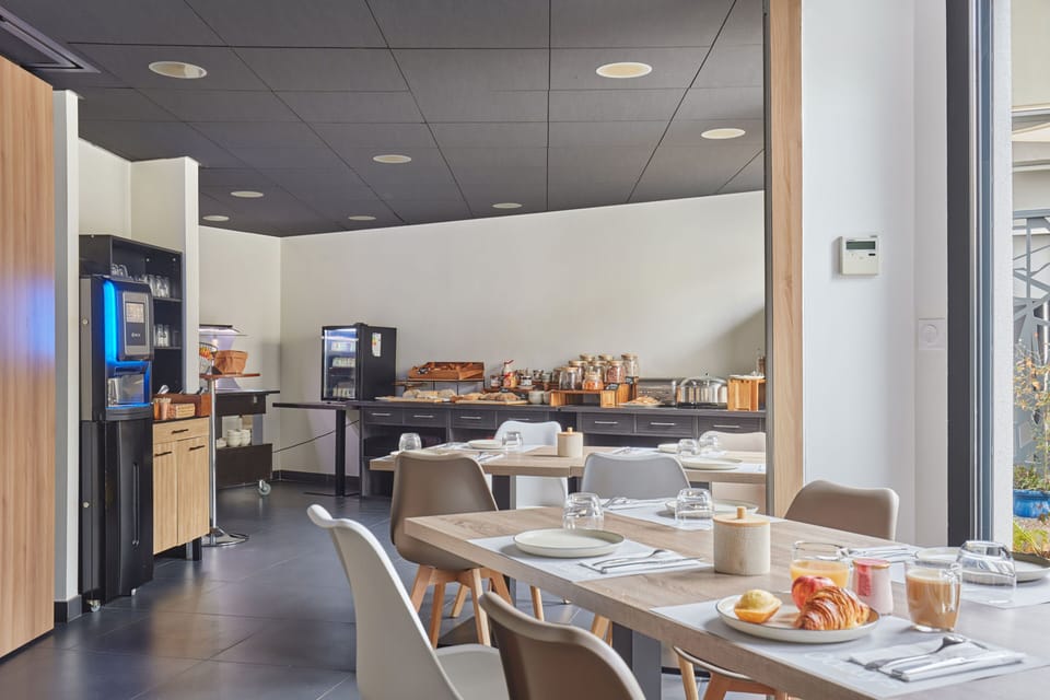 Enjoy a delightful breakfast in the sleek dining area of Aparthotel Prado Castellane, where modern design meets the vibrant energy of Marseille.