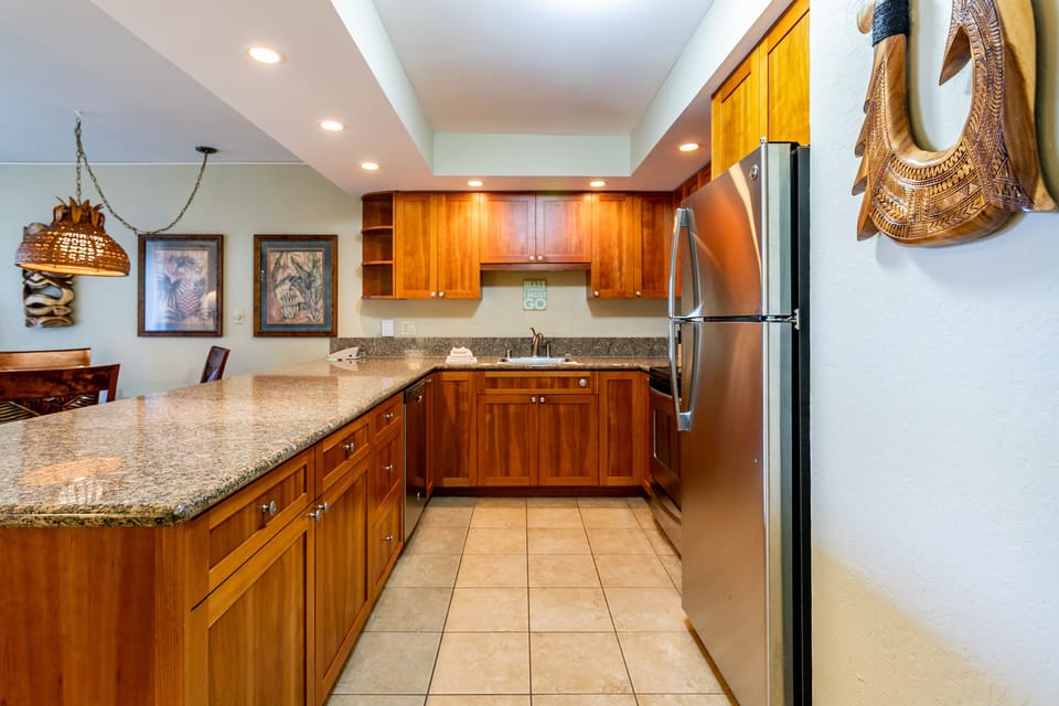 Prepare your favorite meals in this fully equipped kitchen, complete with granite countertops, stainless steel appliances, and rich wood cabinetry.
