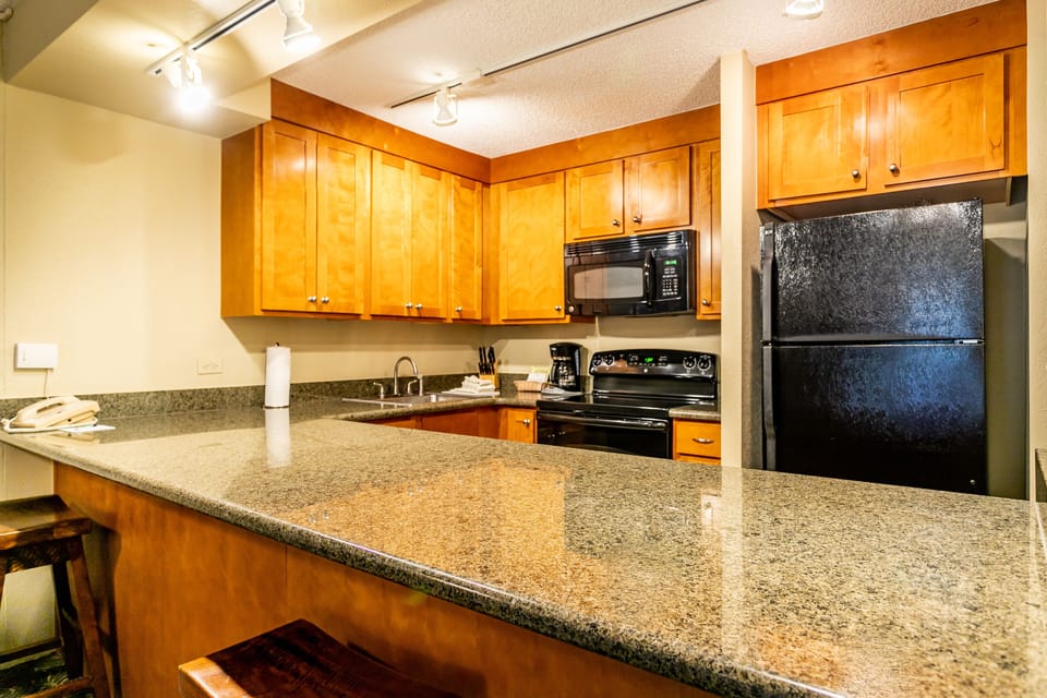 Your fully equipped kitchen features warm wood cabinetry, granite countertops, and modern appliances—everything you need to prepare meals just the way you like them during your stay.