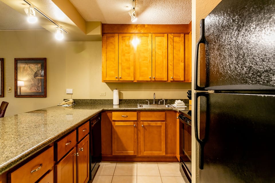 Cook your favorite meals in this fully-equipped kitchen with sleek granite counters, warm wood cabinetry, stainless appliances, and a stylish water feature wall that adds a soothing ambiance to your stay.