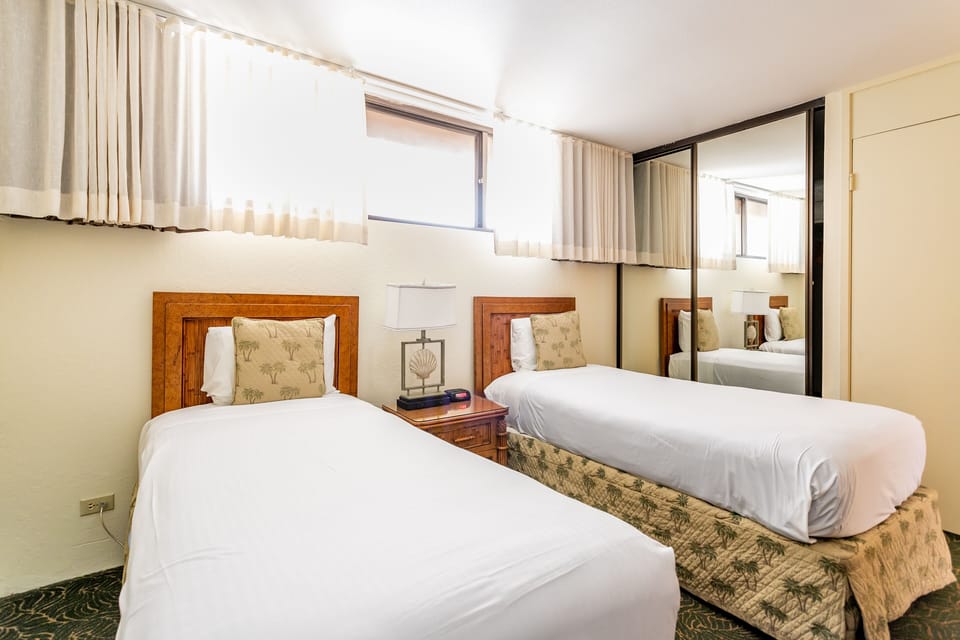 Two cozy beds with elegant wooden headboards await you in this bright, air-conditioned room. Soft linens and thoughtful touches create a restful retreat for your stay.