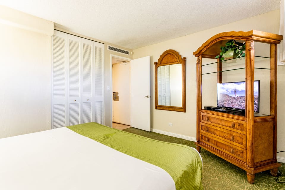 Settle into your comfortable bedroom featuring a cozy bed, entertainment center, and ample closet storage for all your vacation essentials.