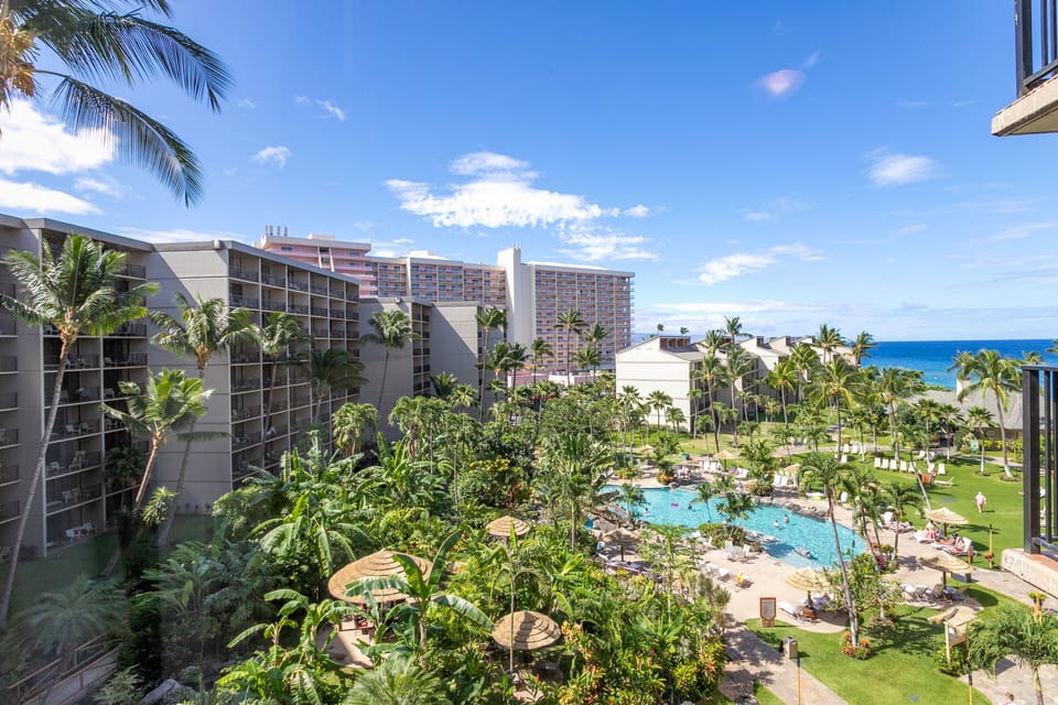Aerial view of the property showcasing lush tropical gardens, a sparkling pool, and the Pacific Ocean backdrop.