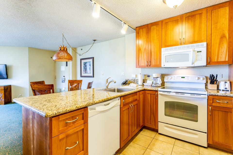 Your fully equipped kitchen features rich wood cabinetry, granite countertops, and modern appliances—perfect for preparing meals in the comfort of home.