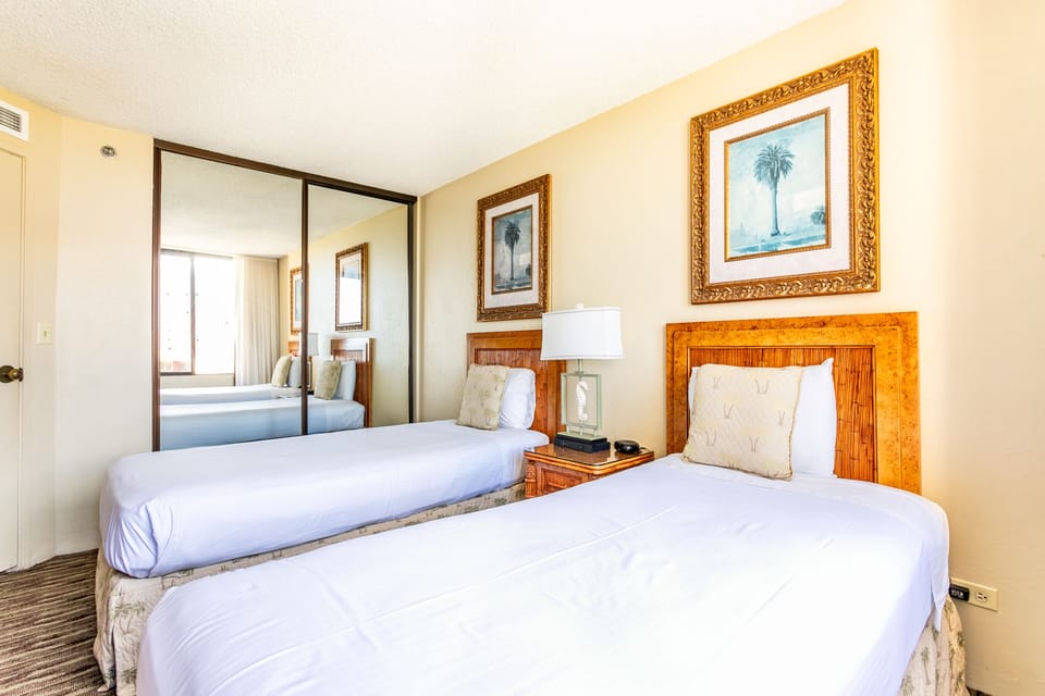 Your bright, coastal-style bedroom features tropical artwork and a mirrored wardrobe that amplifies natural light, creating an airy retreat for restful nights.