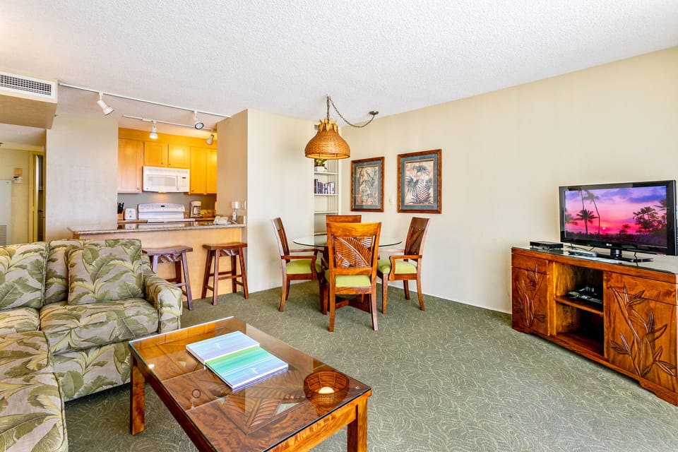 Relax in your spacious living area with tropical-inspired decor, a fully equipped kitchen, and warm wood furnishings that create an inviting island atmosphere.