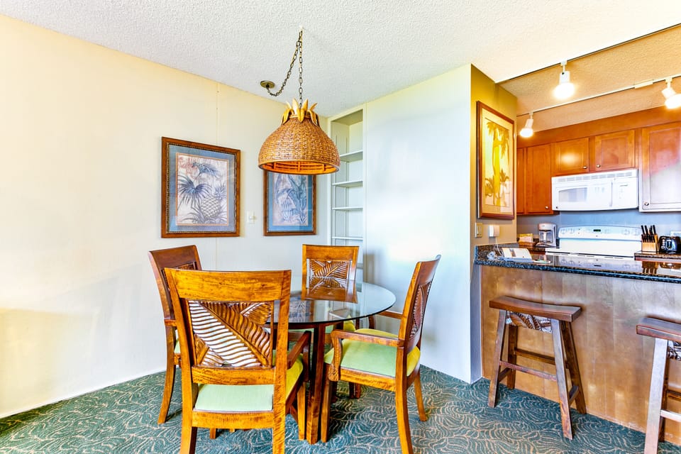 Gather around your tropical-inspired dining table under warm ambient lighting, just steps from your fully equipped kitchen—perfect for creating memories over shared meals.