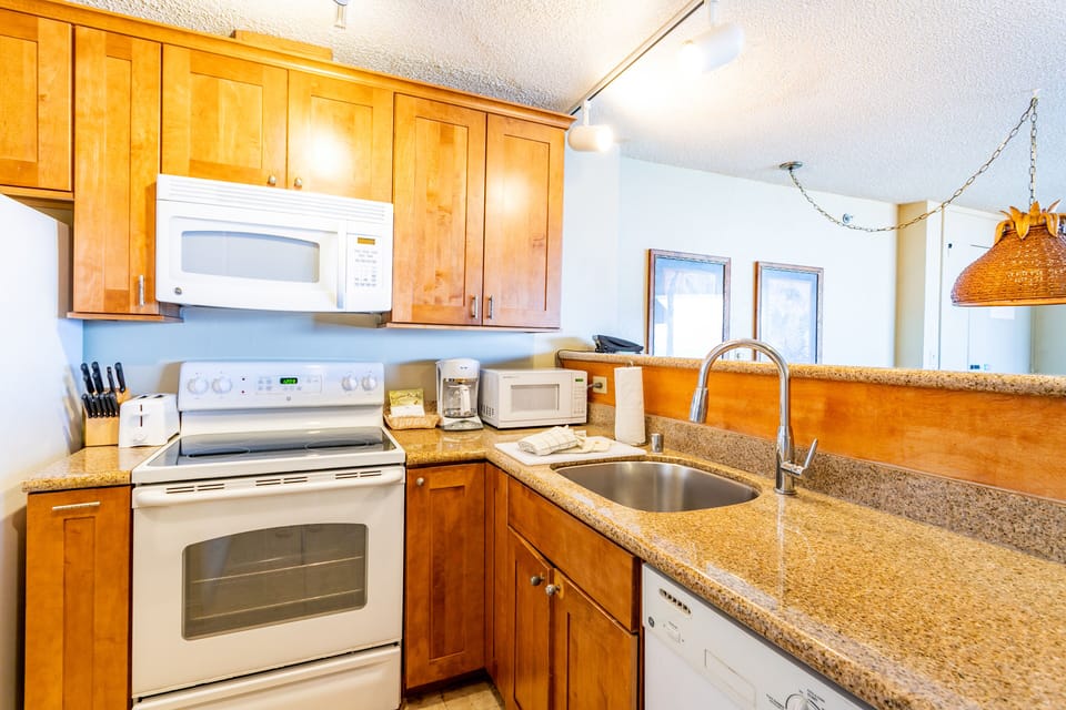 Your fully equipped kitchen features modern appliances and warm wood cabinets, perfect for preparing meals during your mountain getaway. Natural light flows through the windows as you cook and gather.