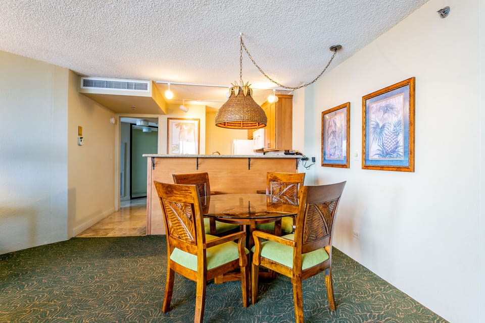 Gather around your tropical-inspired dining table where warm wood tones and island artwork set the scene for memorable meals together, all steps from your open kitchen.