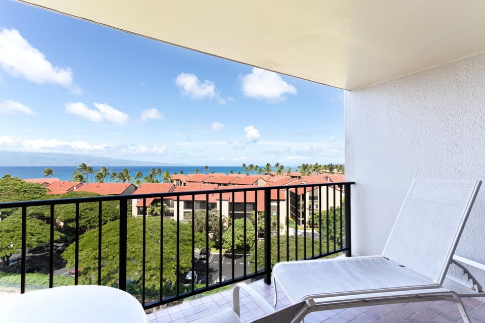 Sip your morning coffee from your private balcony overlooking turquoise waters, swaying palms, and red-tiled roofs. This serene coastal view offers a peaceful escape with room to lounge and unwind in paradise.