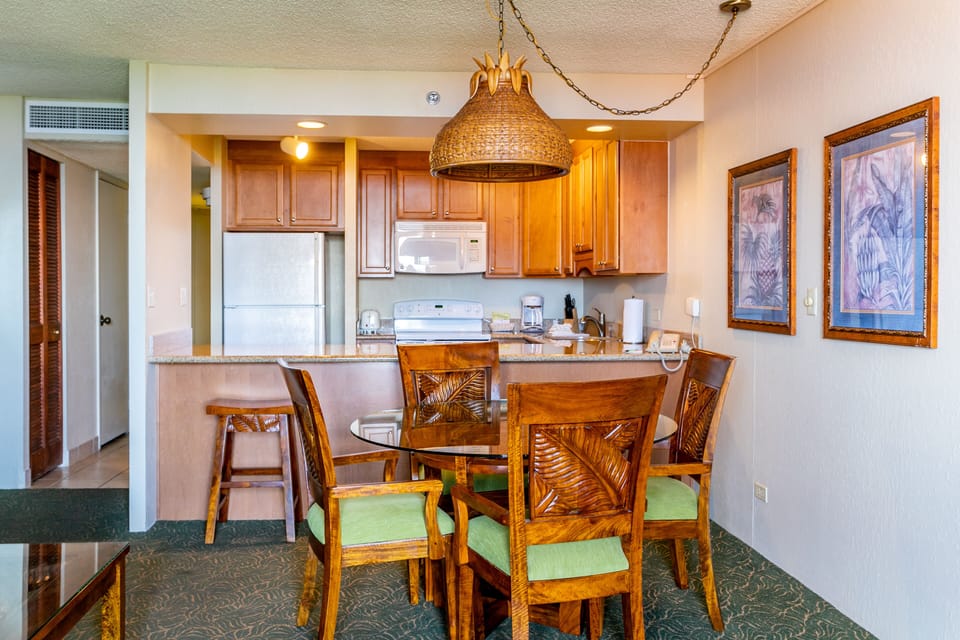 Gather around this inviting dining space that flows seamlessly into your fully equipped kitchen, where tropical-inspired décor and thoughtful details create the perfect setting for memorable meals together.