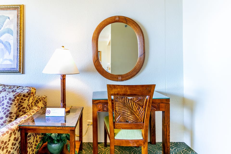 Your private workspace awaits with a handsome wooden desk, ambient lighting, and tropical-inspired furnishings for a productive yet relaxed stay.