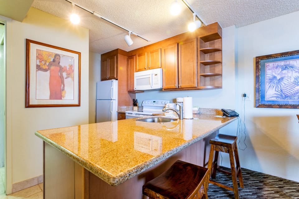 Your fully equipped kitchen features granite countertops, modern appliances, and a breakfast bar for casual dining. Cook meals at your own pace or enjoy island-inspired artwork while sipping morning coffee.