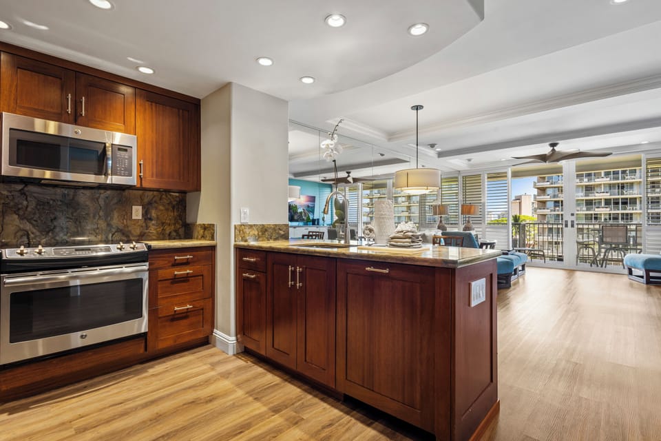 Your gourmet kitchen features rich wood cabinetry, granite countertops, and stainless steel appliances—perfect for preparing meals while enjoying city views from the open layout.
