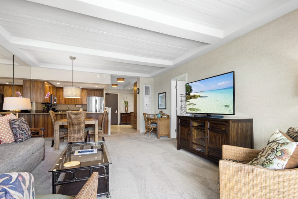 Settle into your open-concept living space where beachy elegance meets comfort—plush seating, a flat-screen TV, and a fully equipped kitchen invite you to unwind and make yourself at home.