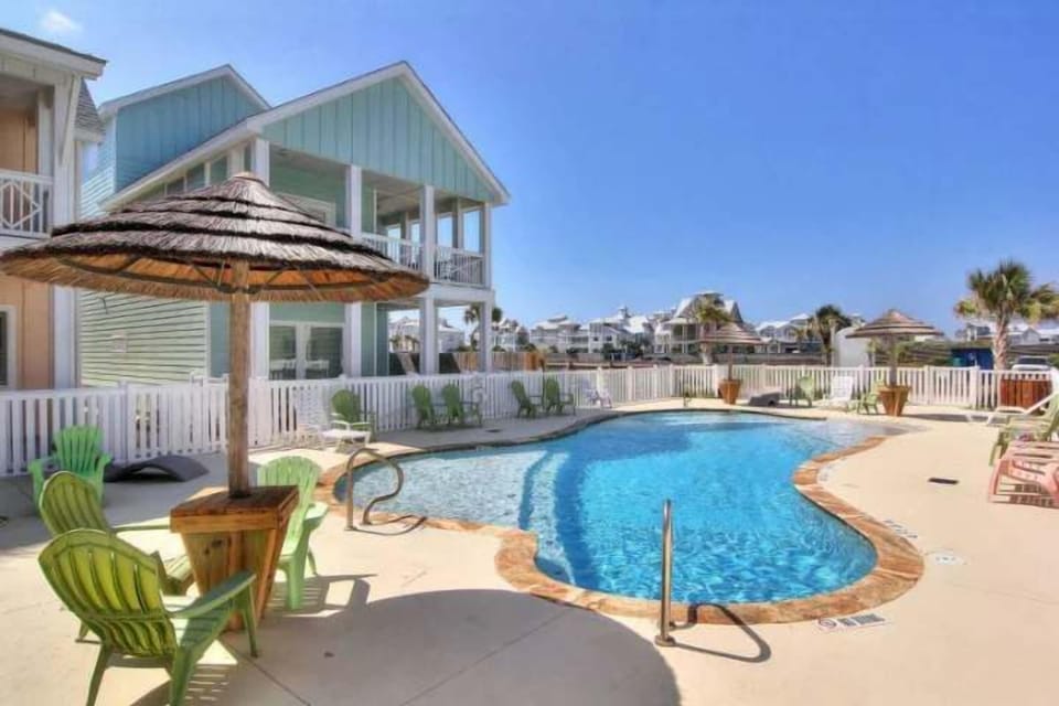 Resort-style pool framed by coastal architecture, ideal for sunny afternoons & laid-back lounging