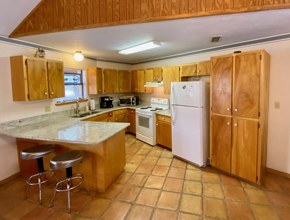 Winding Springs - Kitchen has granite counters, tile floors & island with bar stools.