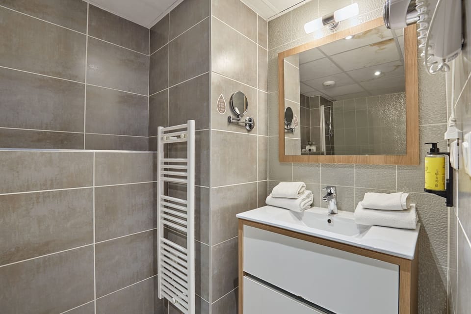 Modern bathroom with walk-in shower, twin vanity, and warm tile tones for a spa-like feel.