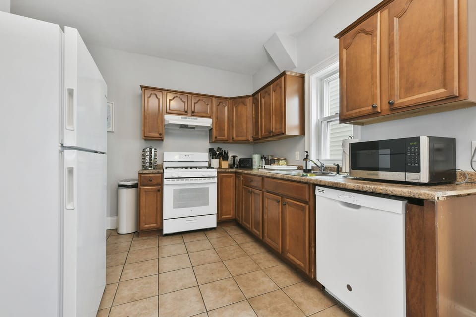 Kitchen, fully stocked with pots, pans, utensils, spices for cooking. 