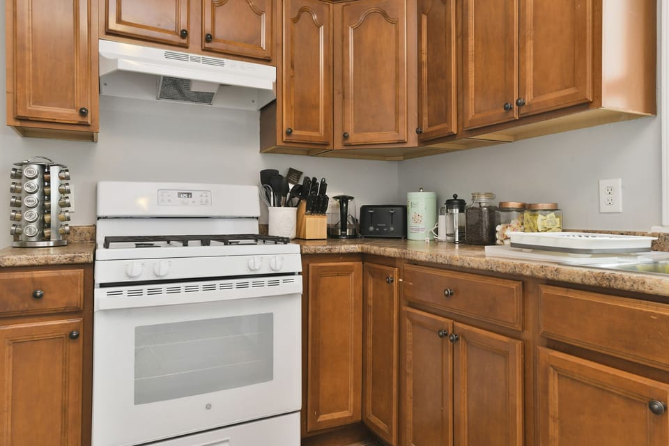 Kitchen, fully stocked with pots, pans, utensils, spices for cooking. 