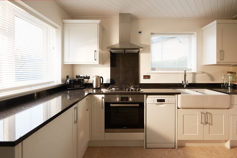 Modern Kitchen featuring granite worktops, natural stone floors & Belfast sink.