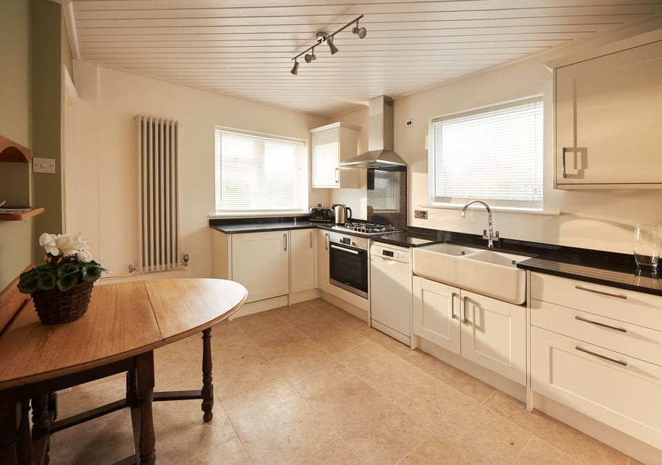 Modern Kitchen featuring granite worktops, natural stone floors & Belfast sink.