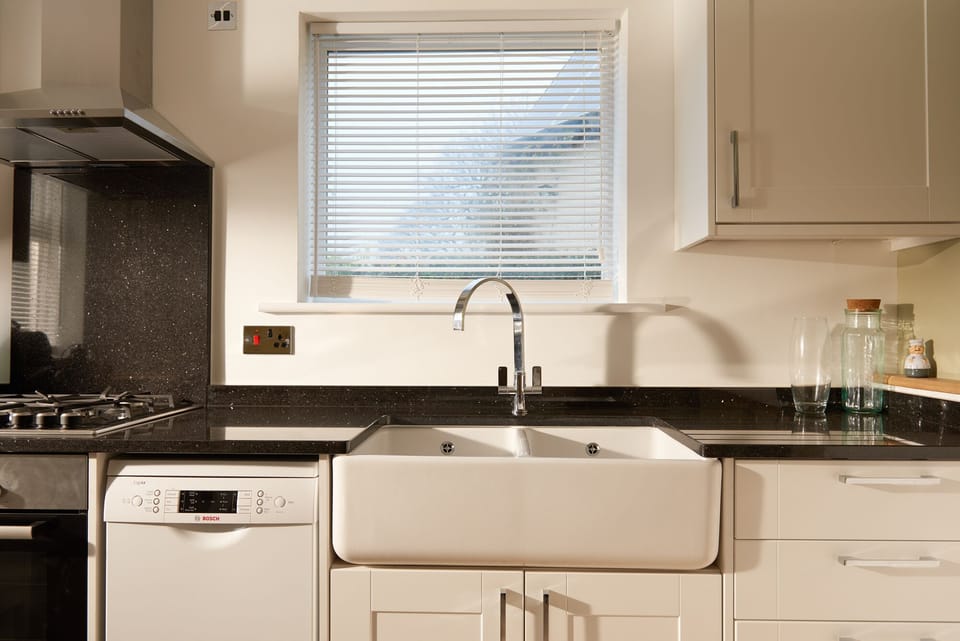 Modern Kitchen featuring granite worktops, natural stone floors & Belfast sink.