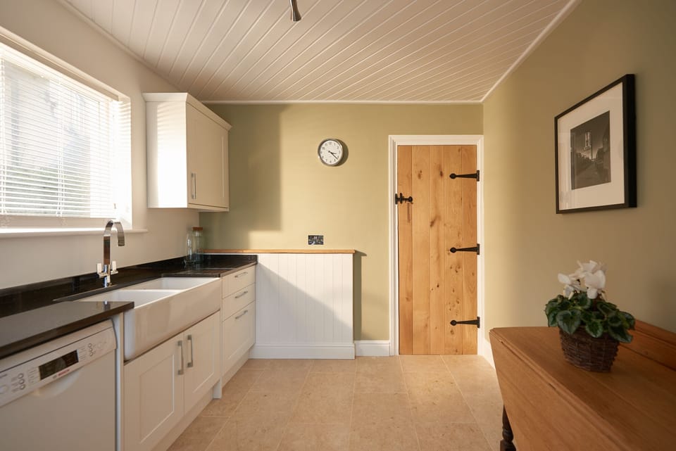 Modern Kitchen featuring granite worktops, natural stone floors & Belfast sink.