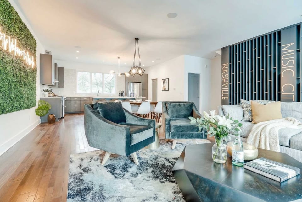 Green armchairs and a coffee table anchor the living room, where the whole crew can gather on hardwood floors between outings and late-night ping pong rounds