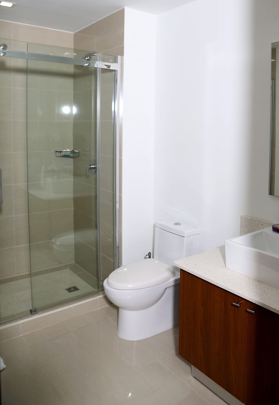 Refresh in your private bathroom with sleek glass shower, modern vanity, and calming neutral tones that make every morning feel like a retreat.
