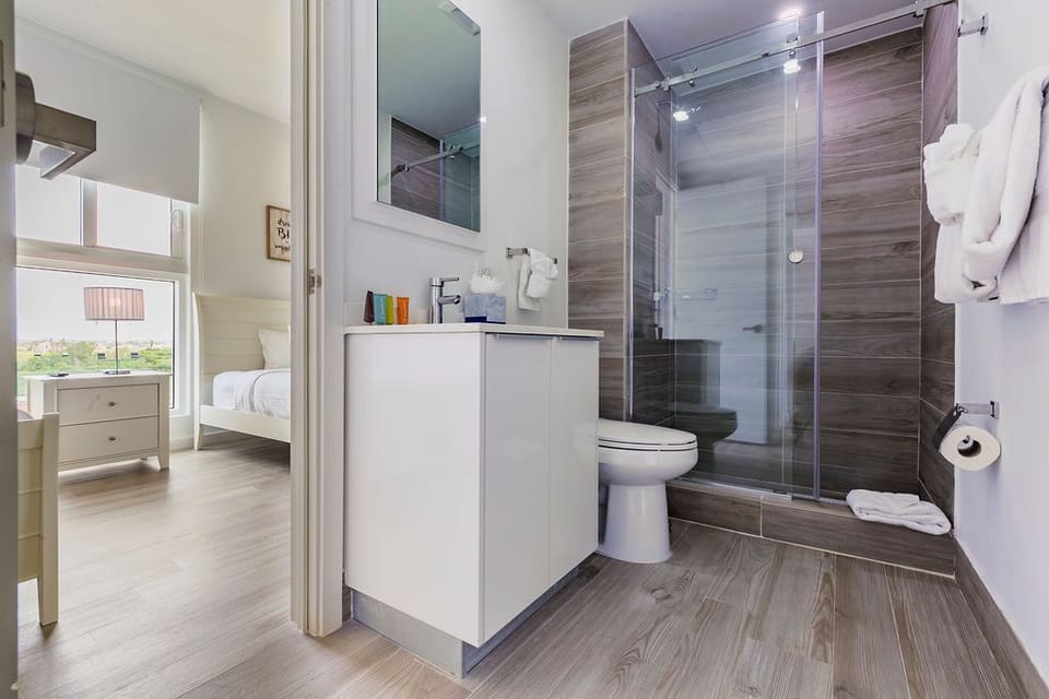 Your ensuite bathroom with sleek modern fixtures, a glass-enclosed shower, and fresh towels awaiting your arrival.
