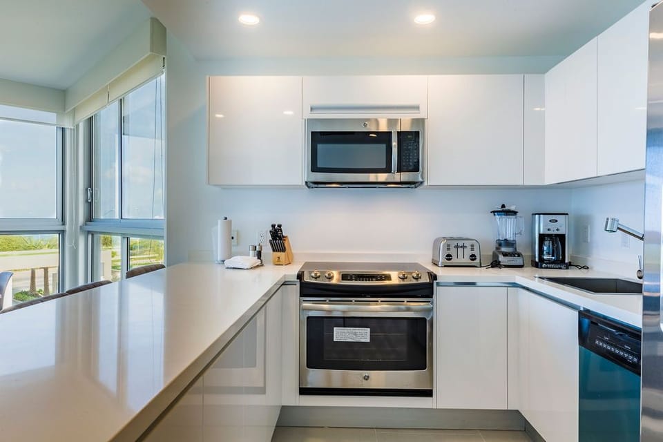 Modern, fully equipped kitchen with stainless-steel appliances, spacious counters, and a bright, open design. Perfect for preparing your morning coffee or a family meal while natural light fills the space.
