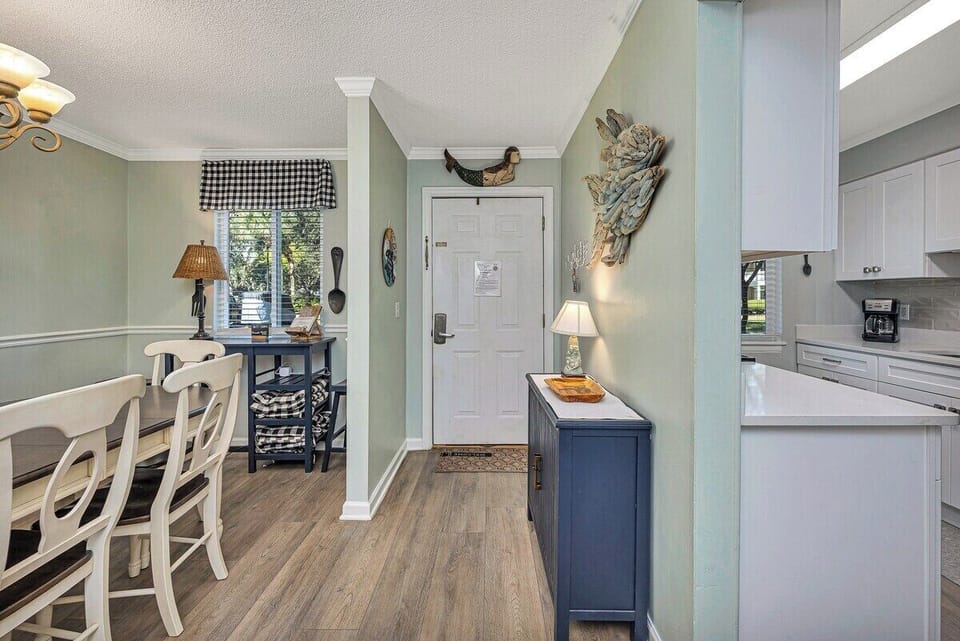 Ocean Walk M2 - Open kitchen and dining area with blue island and hardwood floors