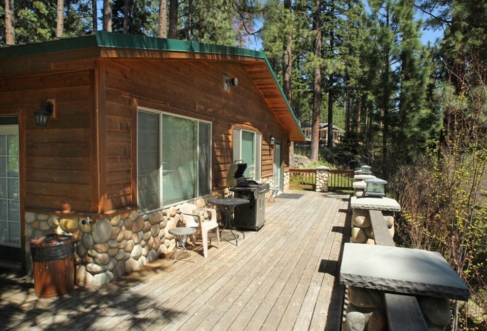 A large deck overlooking Harriman Springs circles two sides of the cabin-house.